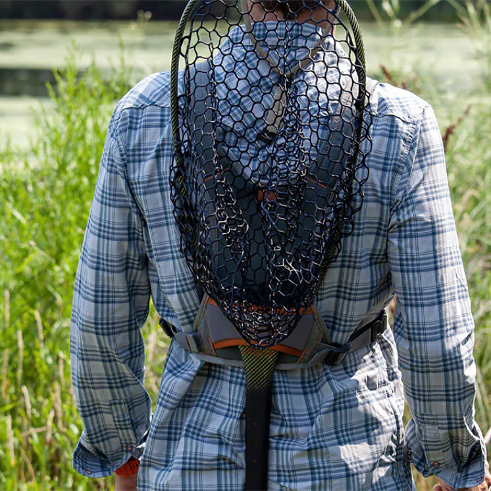 Shown is the Fishpond Canyon Creek Check Pack on a persons back with a fishing net in the net holder on the pack.