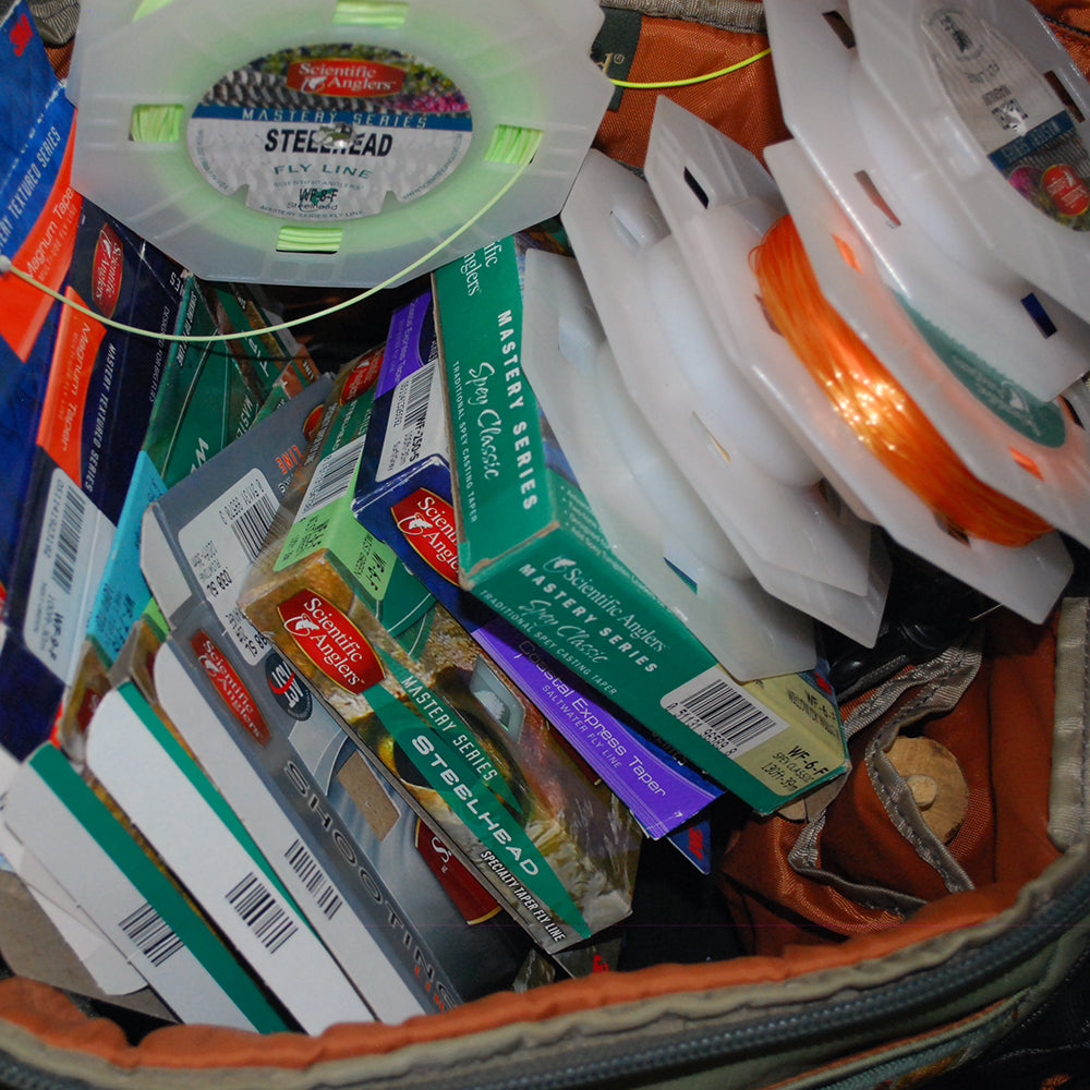 Shown is an assortment of fly lines and fly line boxes shown in a display representing a broad variety of fly lines.